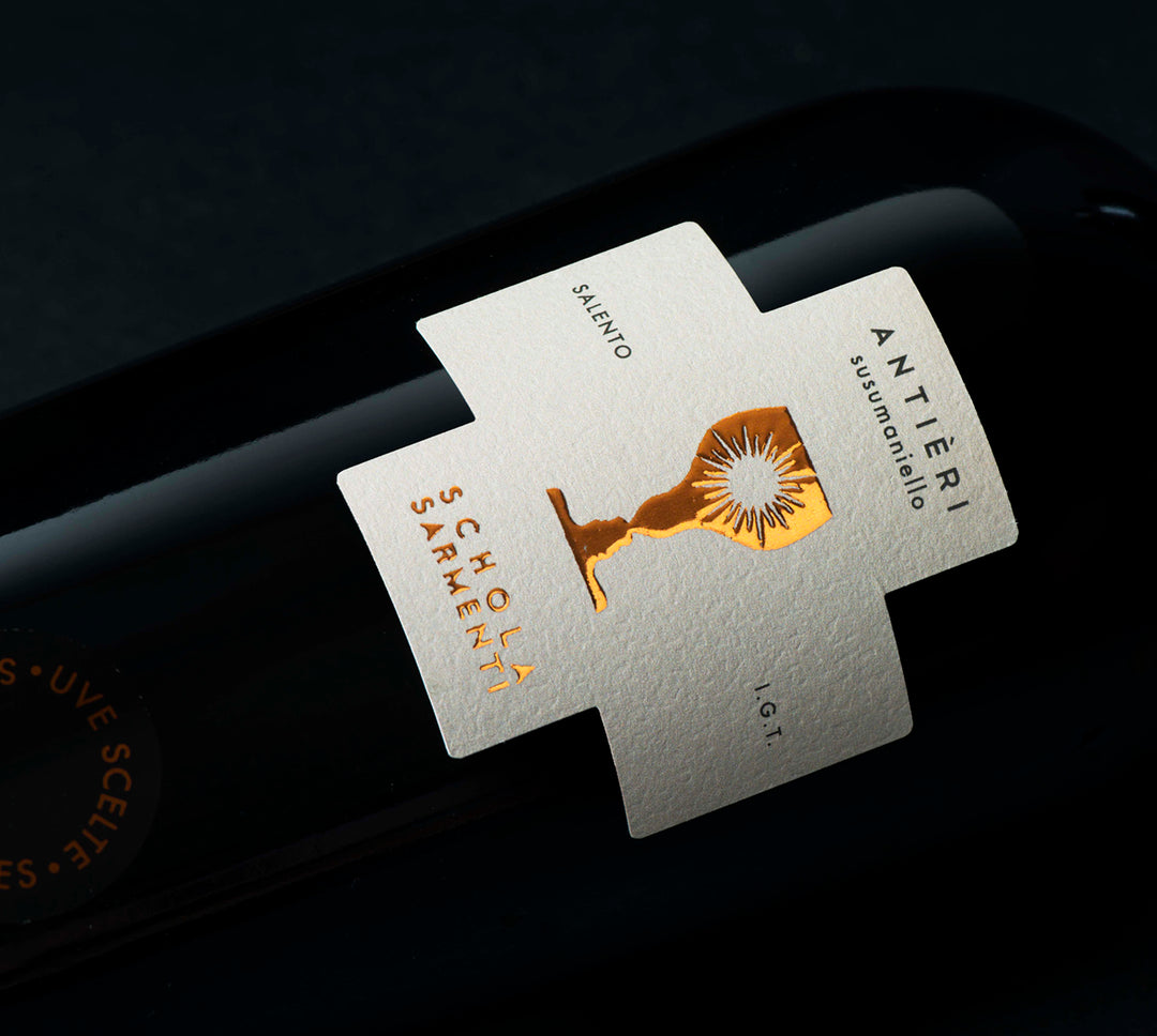 Close-up angled view of the Schola Sarmenti Antièri Susumaniello 2020 wine label from Salento, Puglia, Italy.